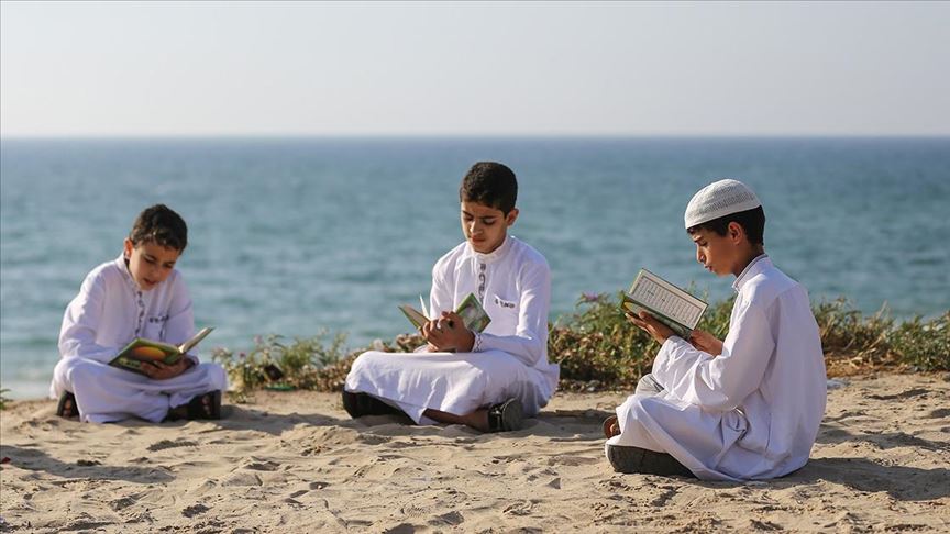 فلسطين المحتلة .. أطفال في عُمر الزهور يقرؤون القُرآن الكريم في سلسلة بشرية على شاطئ غزة .. 